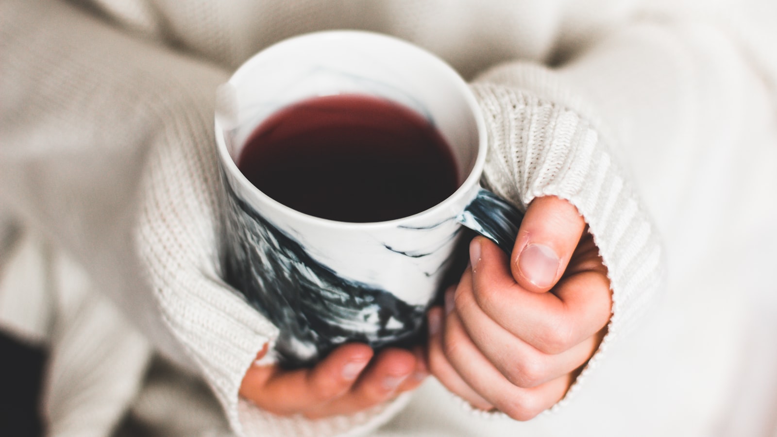 Woman holding a warm cup of coffee — skin in your sixties